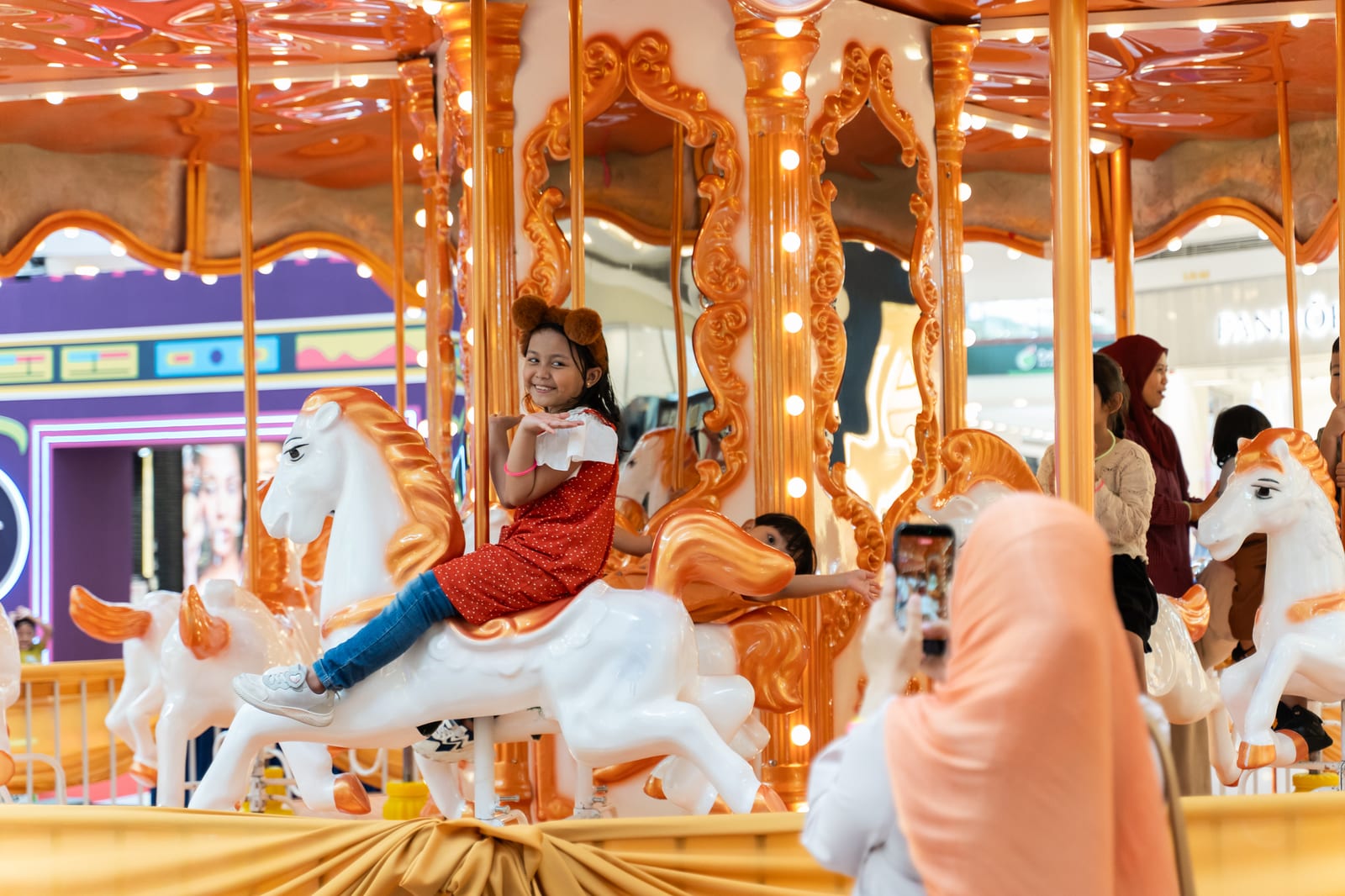 Family enjoying the carousel at Alamanda VIKids Carnival