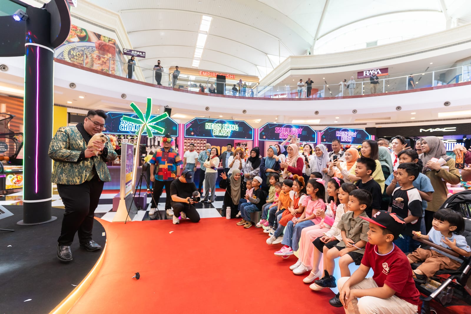 Families watching a weekend performance at Alamanda VIKids Carnival