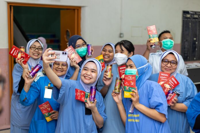 Hospital Sultanah Aminah frontliners holding NESCAFÉ drinks and products during the support initiative in Johor Bahru