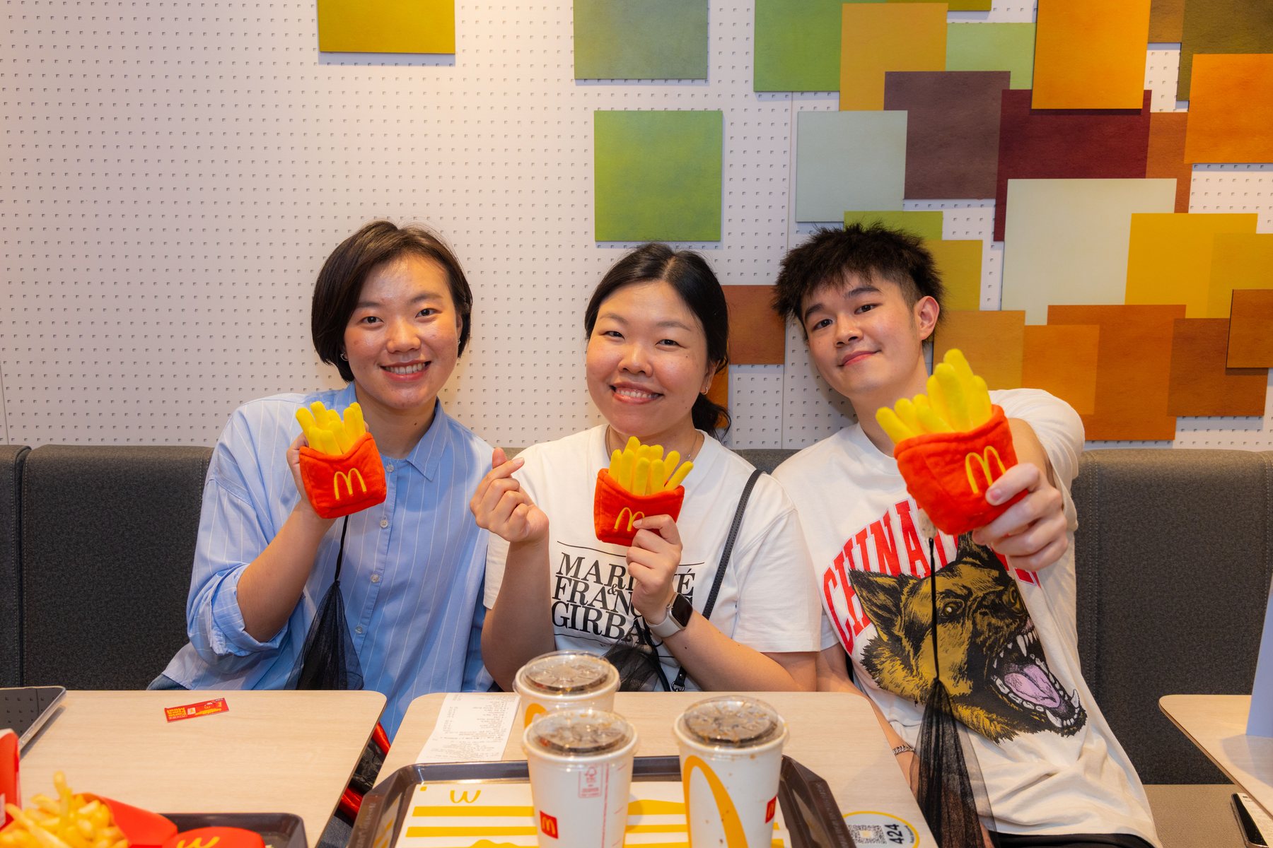 Fans enjoying the McDonald’s Fans Fries Meal with fries-themed plushies