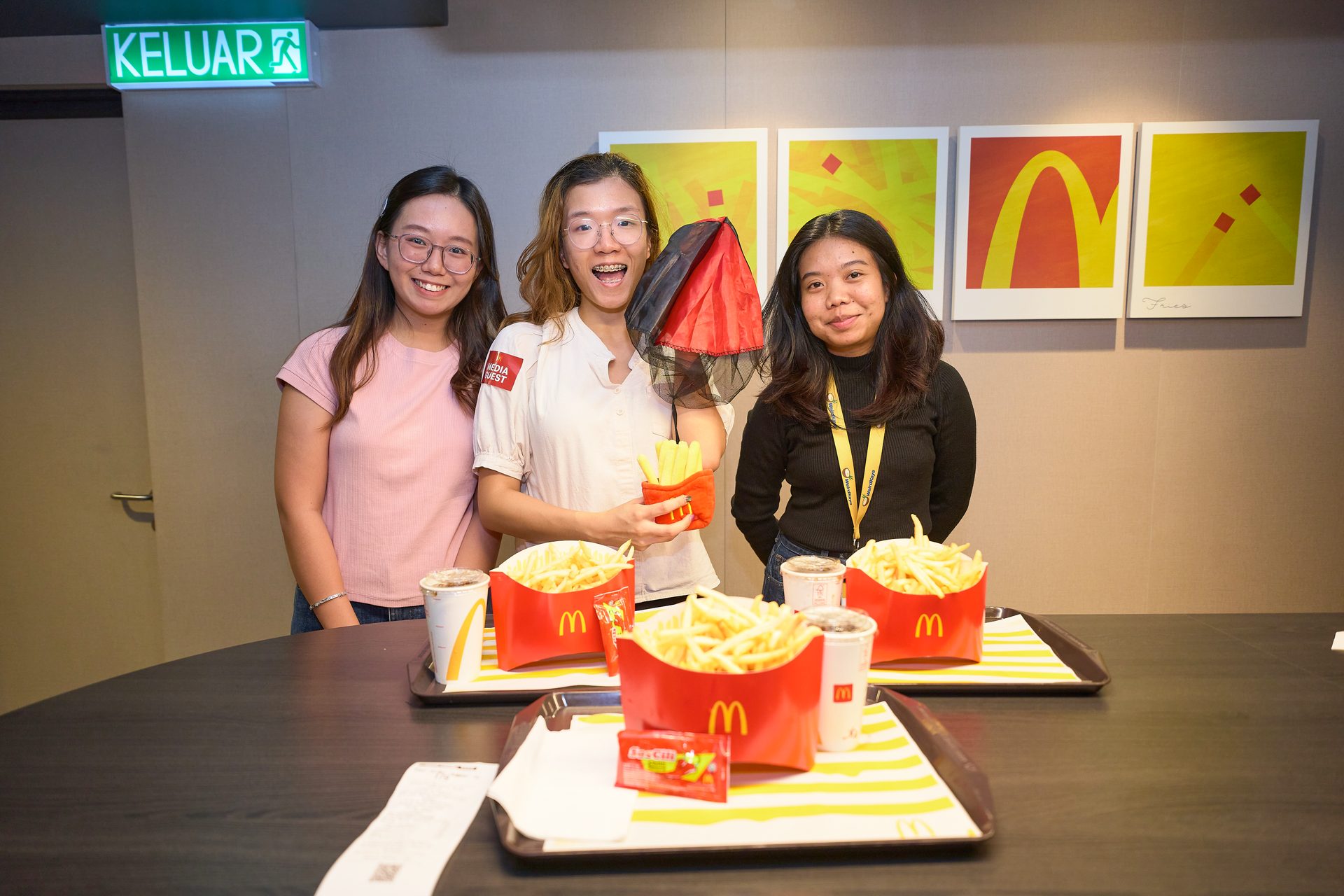 Fans enjoying the McDonald’s Fans Fries Meal with fries-themed plushies